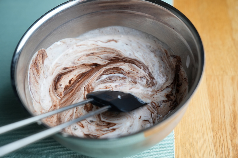 Kokosgrädde hälls över hackad choklad och blandas
